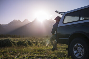 Mann schaut weg, während er auf einem Geländewagen im Grand Teton National Park sitzt - CAVF18284