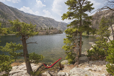 High angle view of man relaxing on hammock by river - CAVF18304