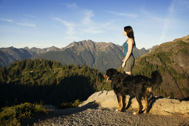 Seitenansicht einer Frau mit Hund auf einem Berg - CAVF18361