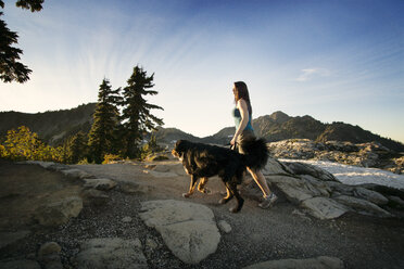 Seitenansicht Frau spaziert mit Hund auf Berg - CAVF18362