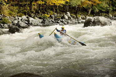 Man rafting in river against forest - CAVF18366