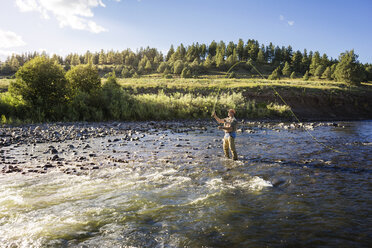 Man fishing in river on sunny day - CAVF18413