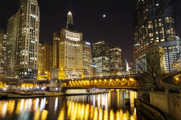 Brücke über den Chicago River vor beleuchtetem Stadtbild bei Nacht - CAVF18470