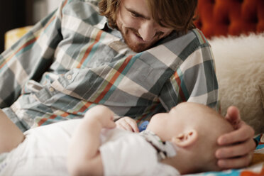 Vater spielt mit Baby im Bett zu Hause - CAVF18510