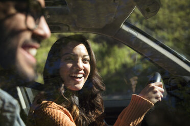 Lächelndes Paar im Auto an einem sonnigen Tag - CAVF18702