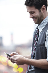 Happy businessman using smart phone on sunny day - CAVF18720