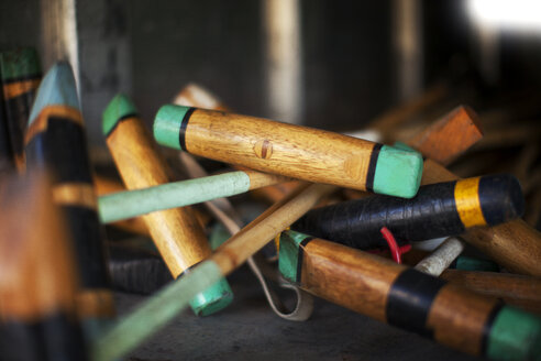 Close-up of wooden polo mallets on floor - CAVF18734