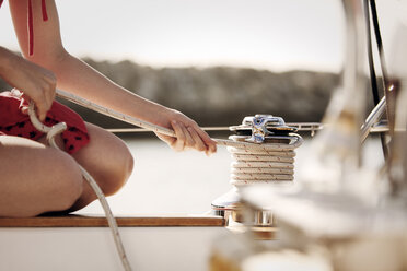 Ausgeschnittenes Bild einer Frau, die ein Seil auf einem Boot bindet - CAVF18765