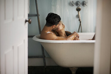 Junges Paar küsst sich in der Badewanne zu Hause - CAVF18905