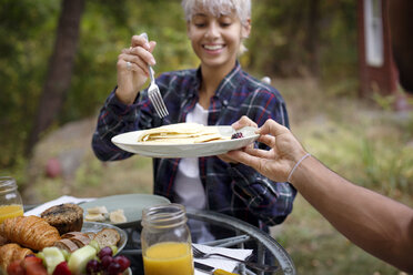 Ausgeschnittenes Bild eines Mannes, der einer jungen Frau beim Frühstück Pfannkuchen anbietet - CAVF18910