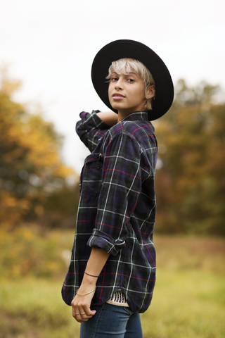 Porträt einer jungen Frau auf einem Feld stehend, lizenzfreies Stockfoto