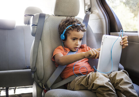 Junge benutzt Tablet-Computer im Auto sitzend - CAVF18934