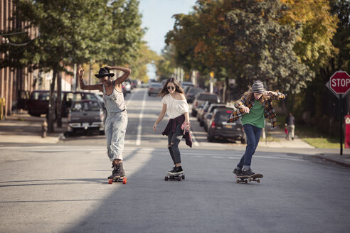 Volle Länge von Freunden beim Skateboardfahren auf der Straße - CAVF19002