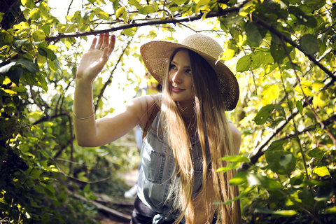 Frau geht durch Bäume im Wald, lizenzfreies Stockfoto