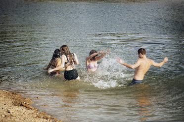 Playful friends enjoying in lake - CAVF19147