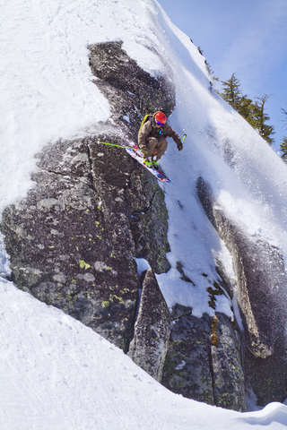 Niedriger Blickwinkel auf Skifahrer, die von einem schneebedeckten Berg abfahren, lizenzfreies Stockfoto