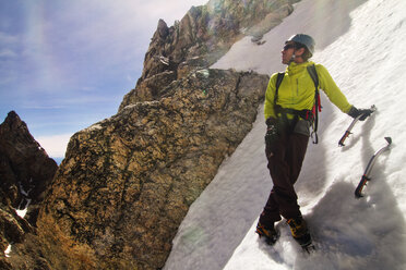 Eiskletterer schaut weg, während er auf einem Berg steht - CAVF19296