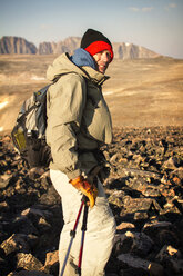 Hiker standing on rocky mountains against sky - CAVF19332