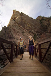Freundinnen gehen auf einer Brücke gegen einen Berg - CAVF19369