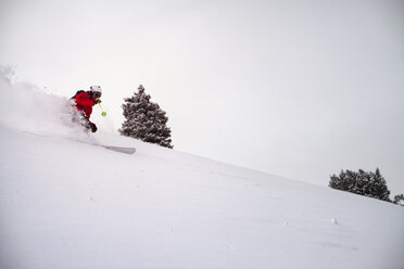 Mann beim Skifahren auf einer Schneepiste gegen den Himmel - CAVF19399