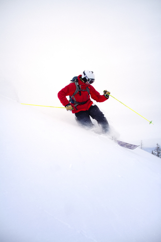 Mann beim Skifahren auf Schneefeld gegen Himmel, lizenzfreies Stockfoto