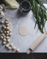 Overhead view of dough balls and vegetables on kitchen counter - CAVF19482