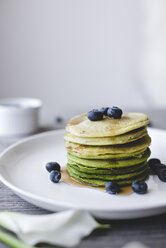 Matcha pancakes with blueberries and syrup in plate - CAVF19498