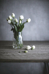 Weiße Rosen im Glas auf Holztisch - CAVF19516