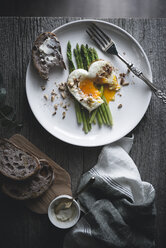 Overhead view of fried egg with asparagus and bread served in plate - CAVF19517