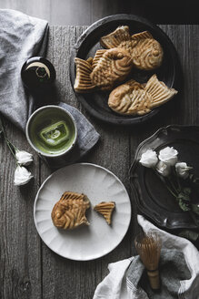 Blick von oben auf Taiyaki mit Matcha-Tee und Rosen auf dem Holztisch - CAVF19522