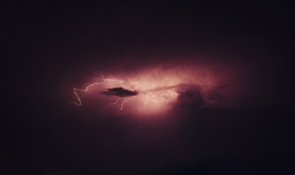 Niedriger Blickwinkel auf gegabelte Blitze vor einem dramatischen Nachthimmel - CAVF19674