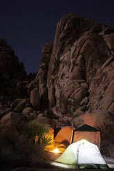 Illuminated tents against rock formations at night - CAVF19733