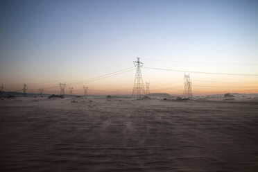 Strommasten auf einem Feld gegen den klaren Himmel bei Sonnenuntergang - CAVF19736