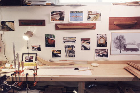 Photographs of boats stuck on wall in workshop - CAVF19999