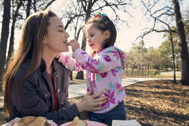 Daughter feeding mother at park - CAVF20074