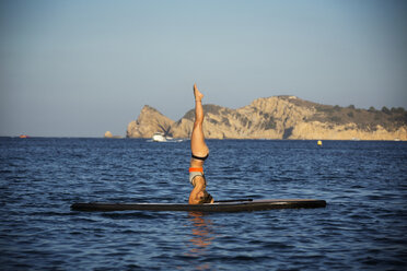 Weibliche Athletin trainiert auf dem Paddleboard auf dem Meer gegen den klaren Himmel - CAVF20077