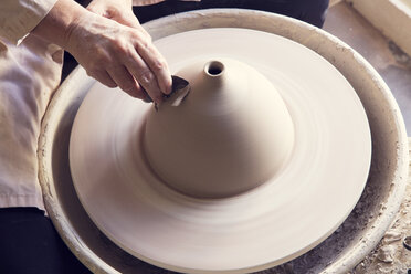 High angle view of woman molding shape to clay on pottery wheel - CAVF20109