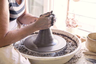 Close-up of woman's hands molding clay on wheel stock photo