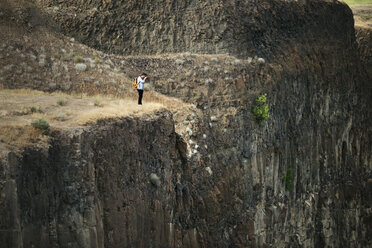 Männlicher Wanderer, der auf einem Berg stehend fotografiert - CAVF20145