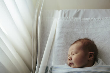 Overhead view of newborn baby girl sleeping in crib at hospital - CAVF20173