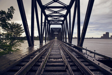 Railway bridge over river against cloudy sky - CAVF20184