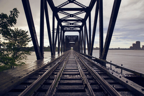 Eisenbahnbrücke über den Fluss gegen bewölkten Himmel - CAVF20184