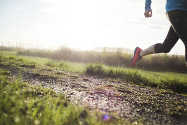 Low section of woman running on field against sky - CAVF20220