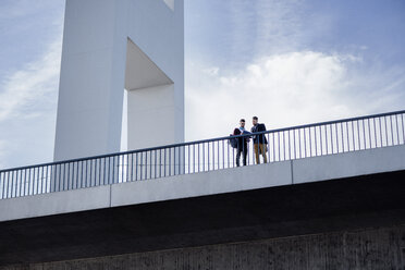 Niedriger Blickwinkel von Männern, die auf einer Brücke vor dem Himmel stehen - CAVF20309
