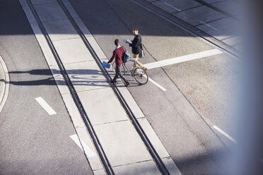 Hohe Winkel Ansicht von Freunden zu Fuß mit Fahrrad auf der Straße - CAVF20314