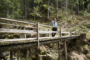 Wanderin steht auf einem Steg im Wald - CAVF20334