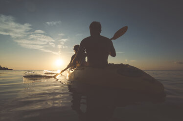Silhouette friends kayaking on sea during sunset - CAVF20379