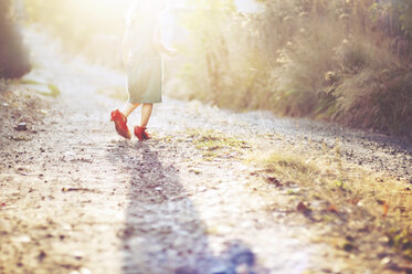 Rückansicht eines Mädchens auf einem Fußweg an einem sonnigen Tag - CAVF20385