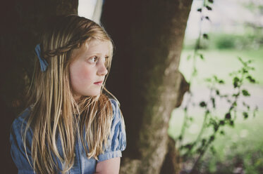 Thoughtful girl sitting at park - CAVF20398