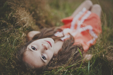 High angle portrait of girl lying on field - CAVF20452